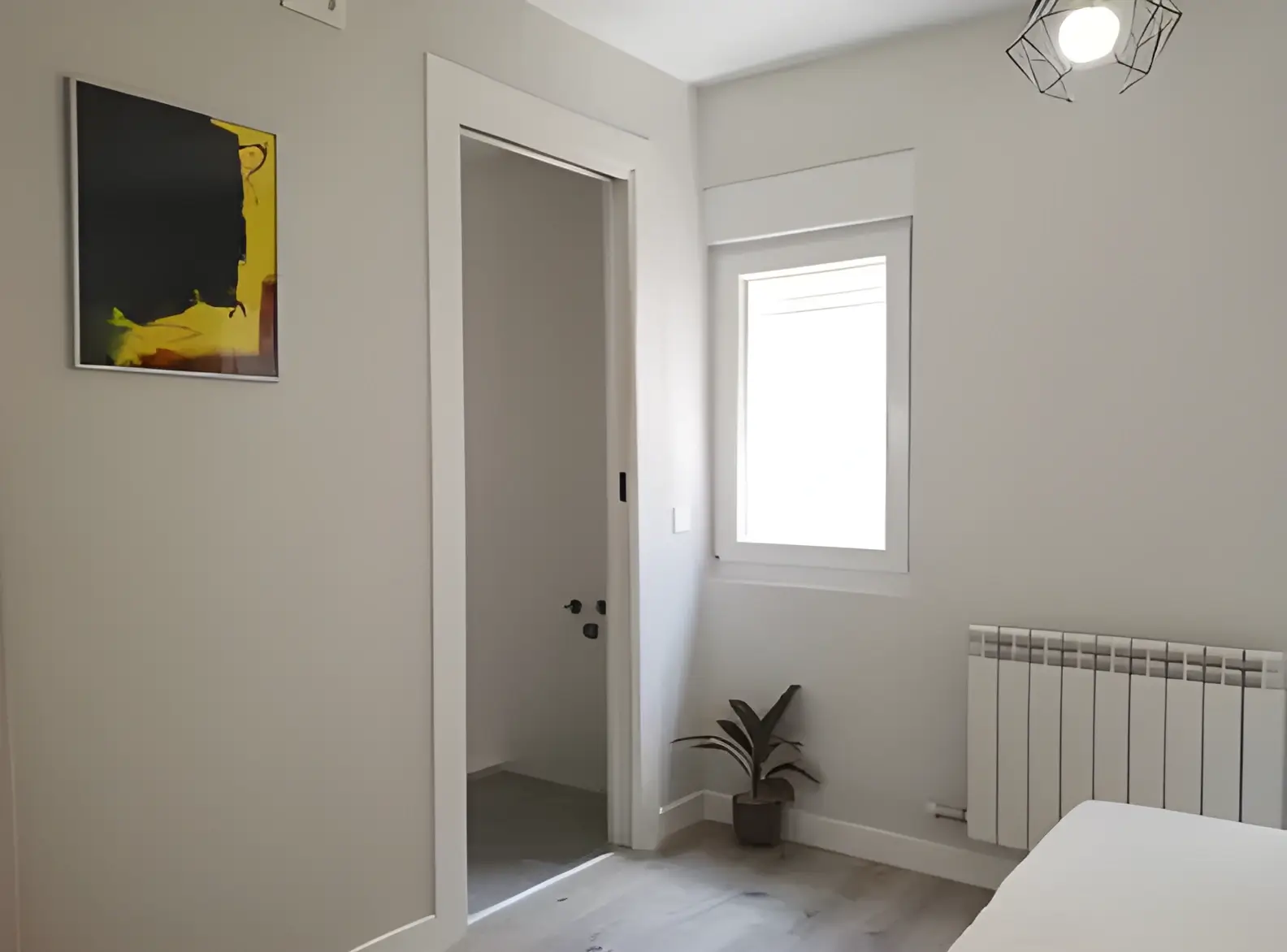 Habitación recién pintada en blanco por Los Pintores Alcorcón para comunidad de vecinos
