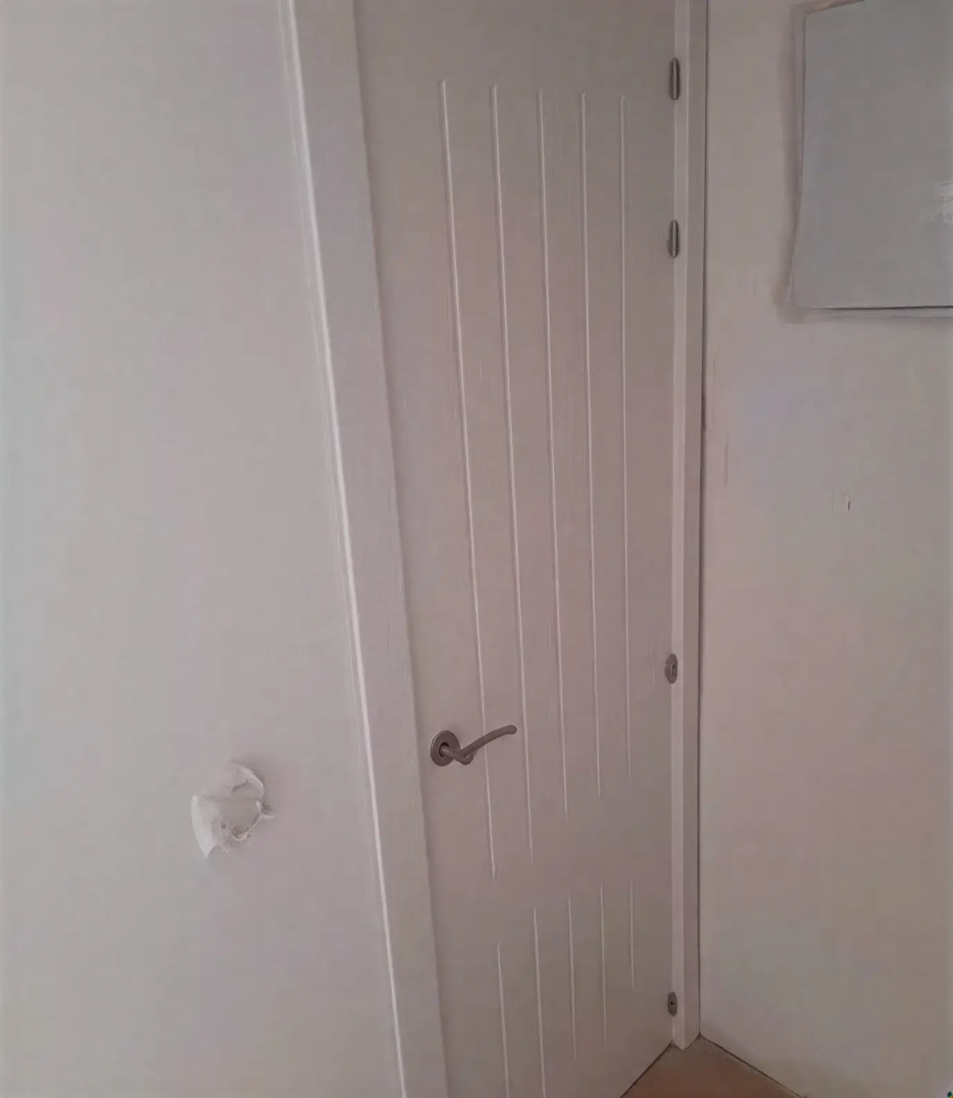 Puerta moderna con ranuras lacada en blanco por pintores profesionales en Alcorcón